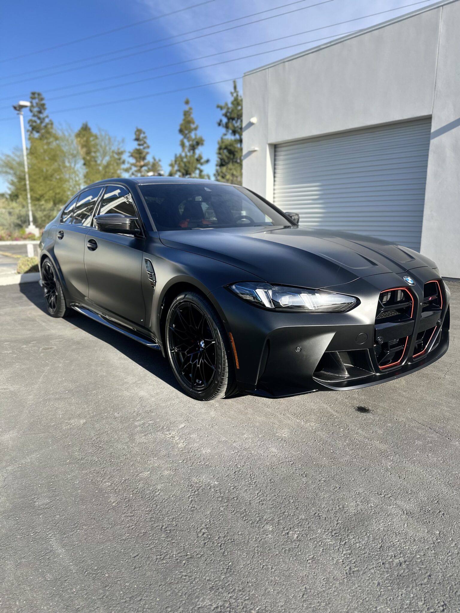 a matte black BMW M3 parked in front of Cda Detailing in riverside ca no.1 ppf shop