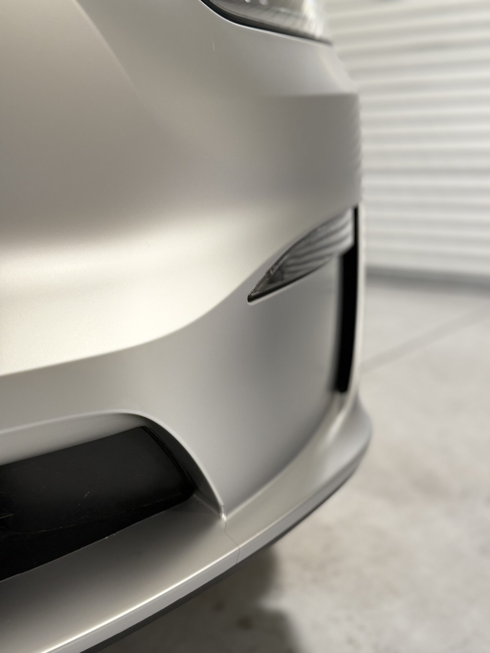 Close-up of right front bumper on 2025 Tesla model X wrapped in satin SVG paint protection film at CDA auto style