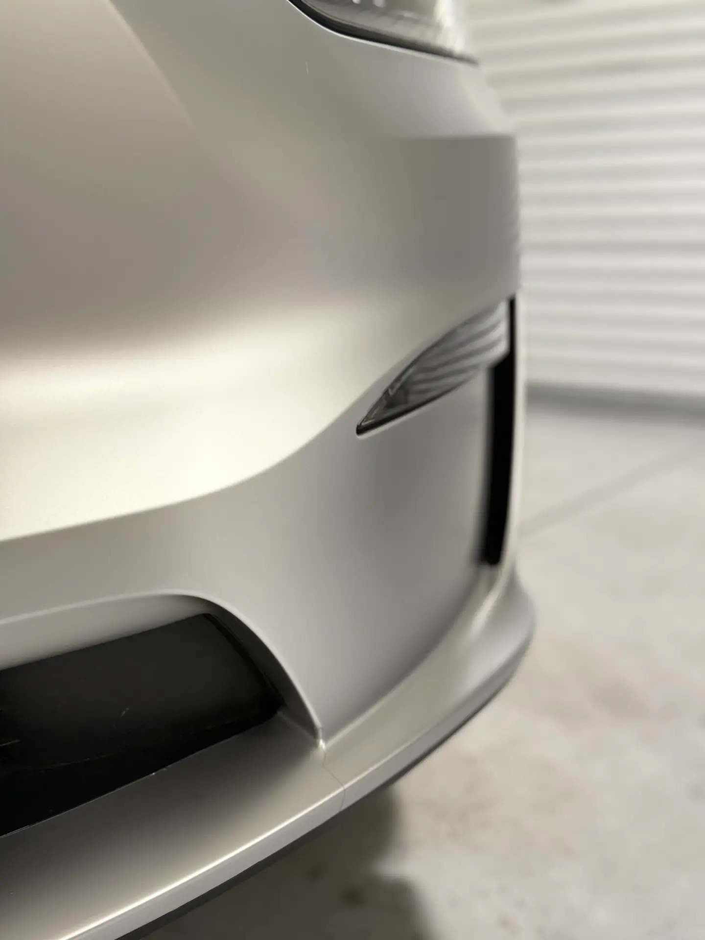 Close-up of right front bumper on 2025 Tesla model X wrapped in satin SVG paint protection film at CDA auto style